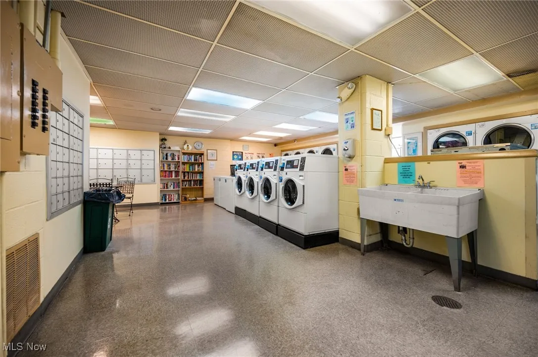 Community laundry room with washer and clothes dryer
