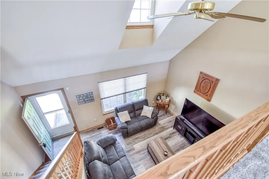 Living area featuring wood finished floors, ceiling fan, and high vaulted ceiling