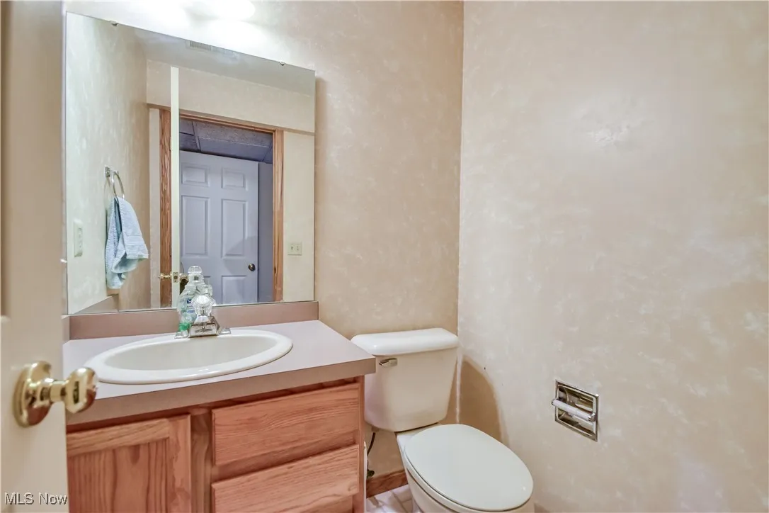 Half bathroom featuring vanity and a textured wall