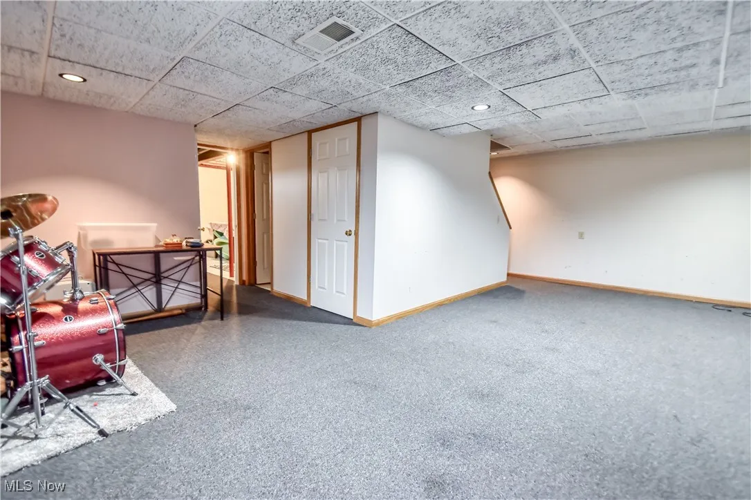 Finished below grade area featuring carpet floors, a drop ceiling, and recessed lighting