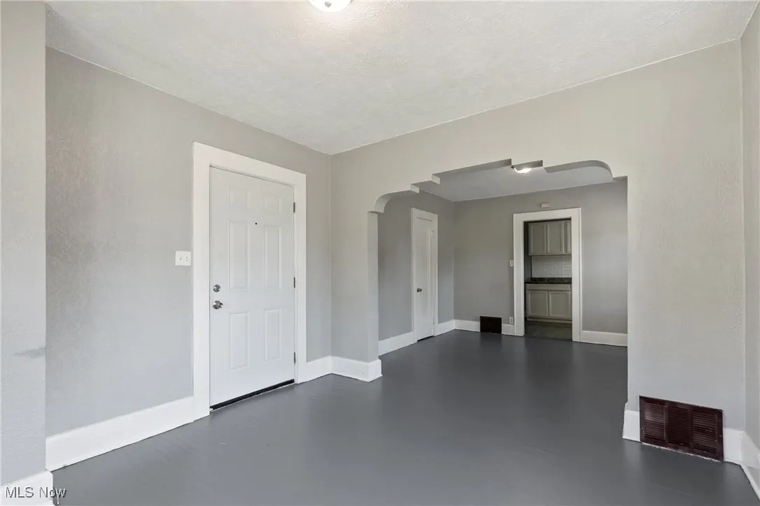 Entryway with arched walkways and a textured ceiling