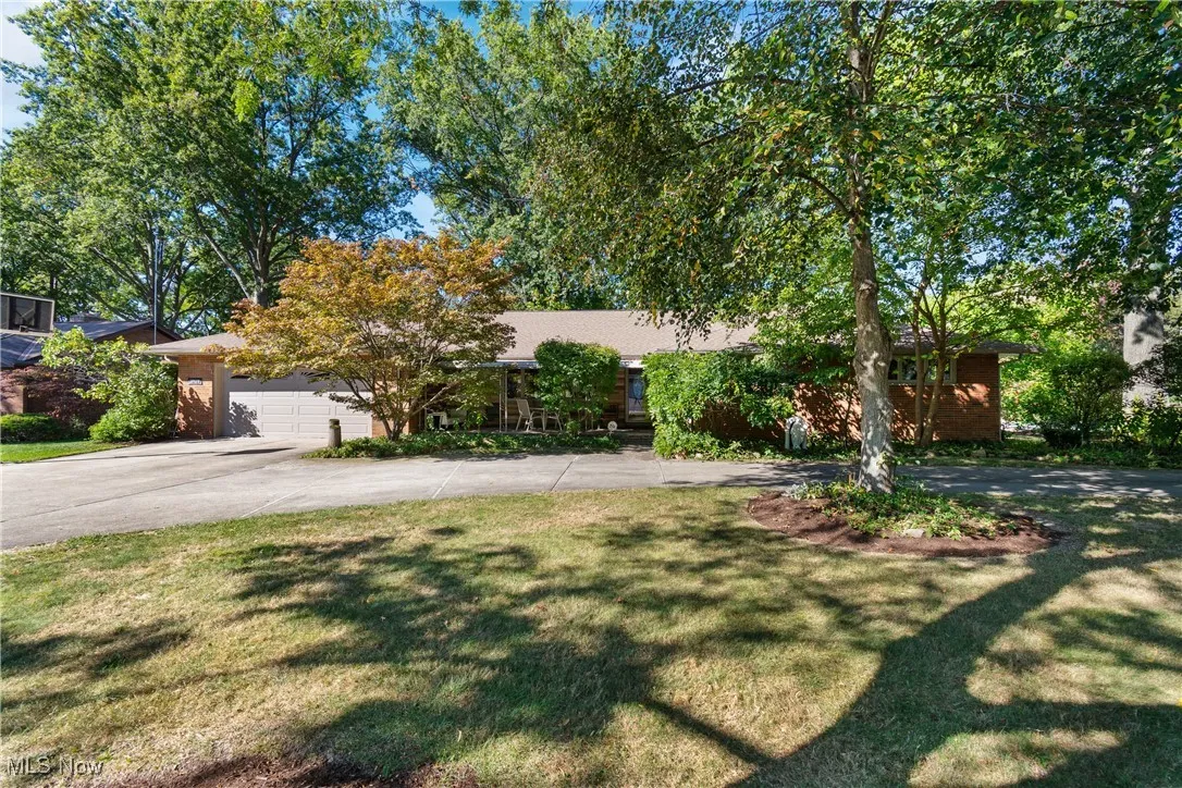 View of front facade with driveway, a front yard, and an attached garage