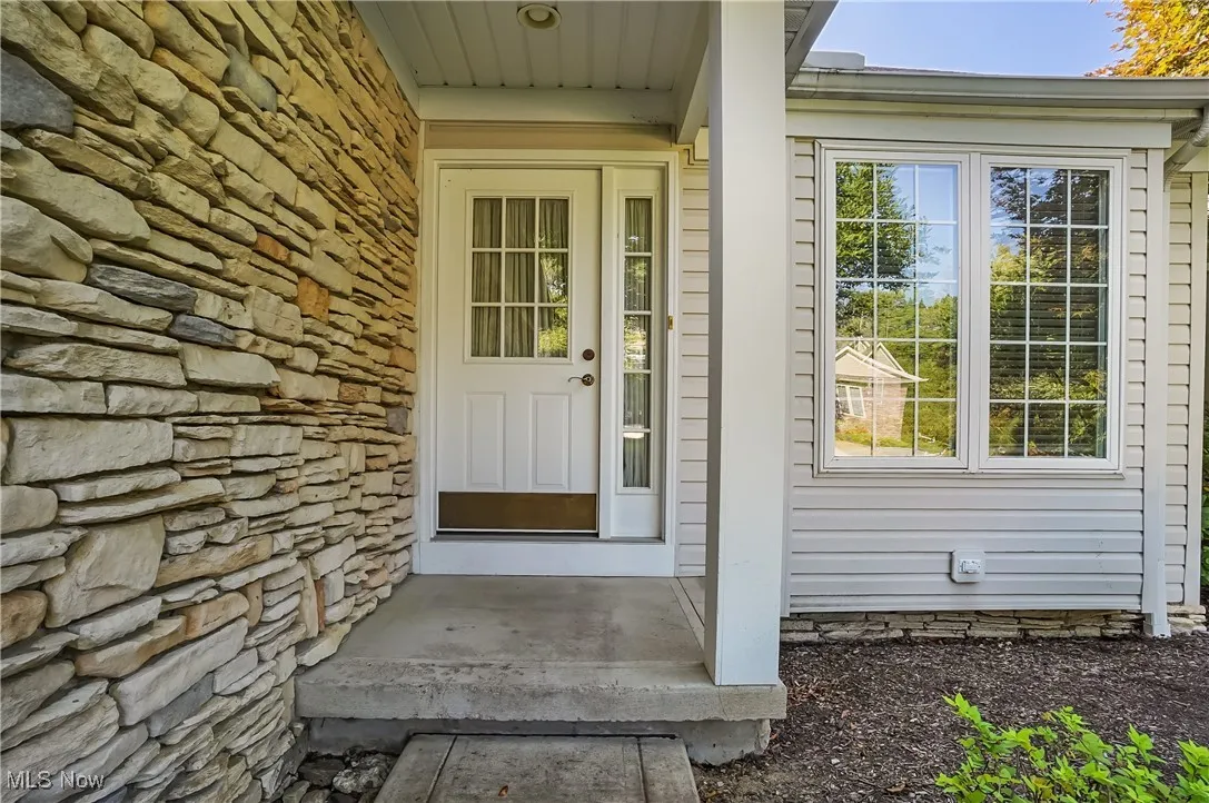 Doorway to property featuring stone siding