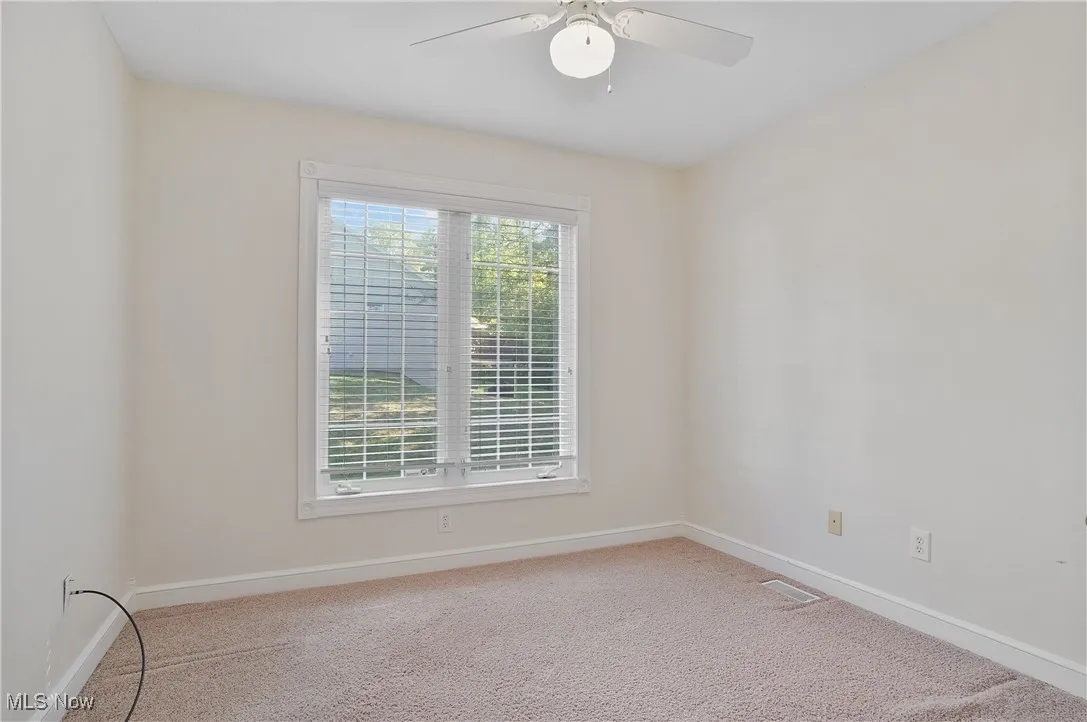 2nd bedroom featuring light carpet and a ceiling fan
