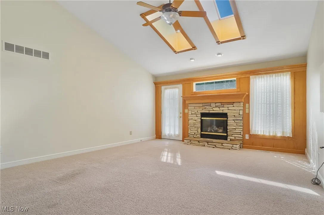  high vaulted ceiling, a skylight, stone fireplace, door out to deck