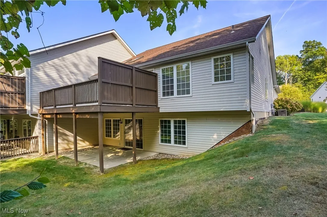 Rear view of property with a patio area, a yard, and a wooden deck