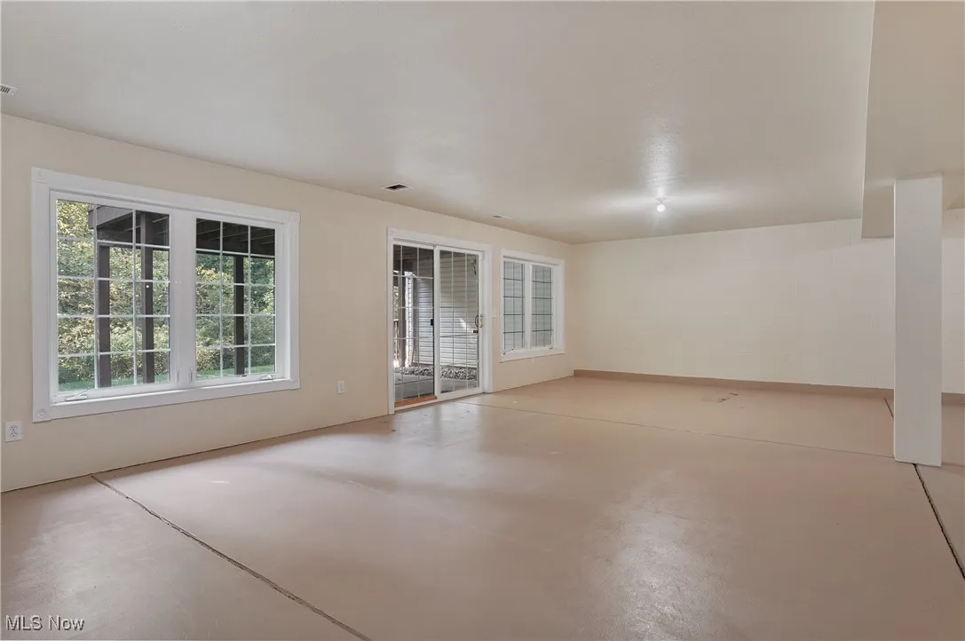 full basement rec room featuring concrete floors, slider out to covered patio