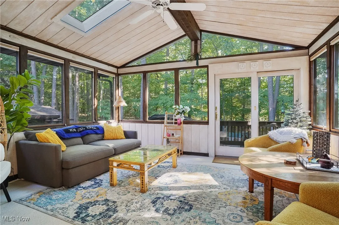Sunroom / solarium with vaulted ceiling, wood ceiling, and a skylight