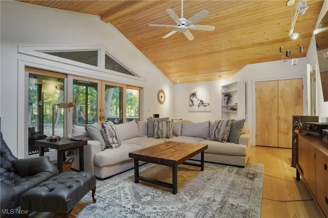 Living area with wood ceiling, light wood-type flooring, track lighting, high vaulted ceiling, and ceiling fan