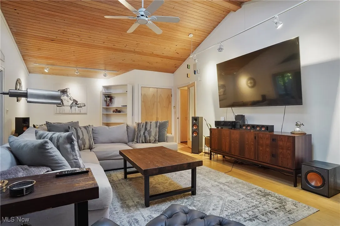 Living room featuring track lighting, light wood-type flooring, wood ceiling, a ceiling fan, and high vaulted ceiling