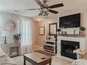 Living area featuring a fireplace and a ceiling fan