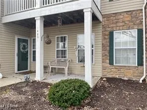 Doorway to property with stone siding and a patio