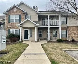 Traditional-style home featuring a balcony and a front lawn