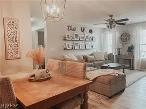Dining space with a chandelier, wood finished floors, and ceiling fan