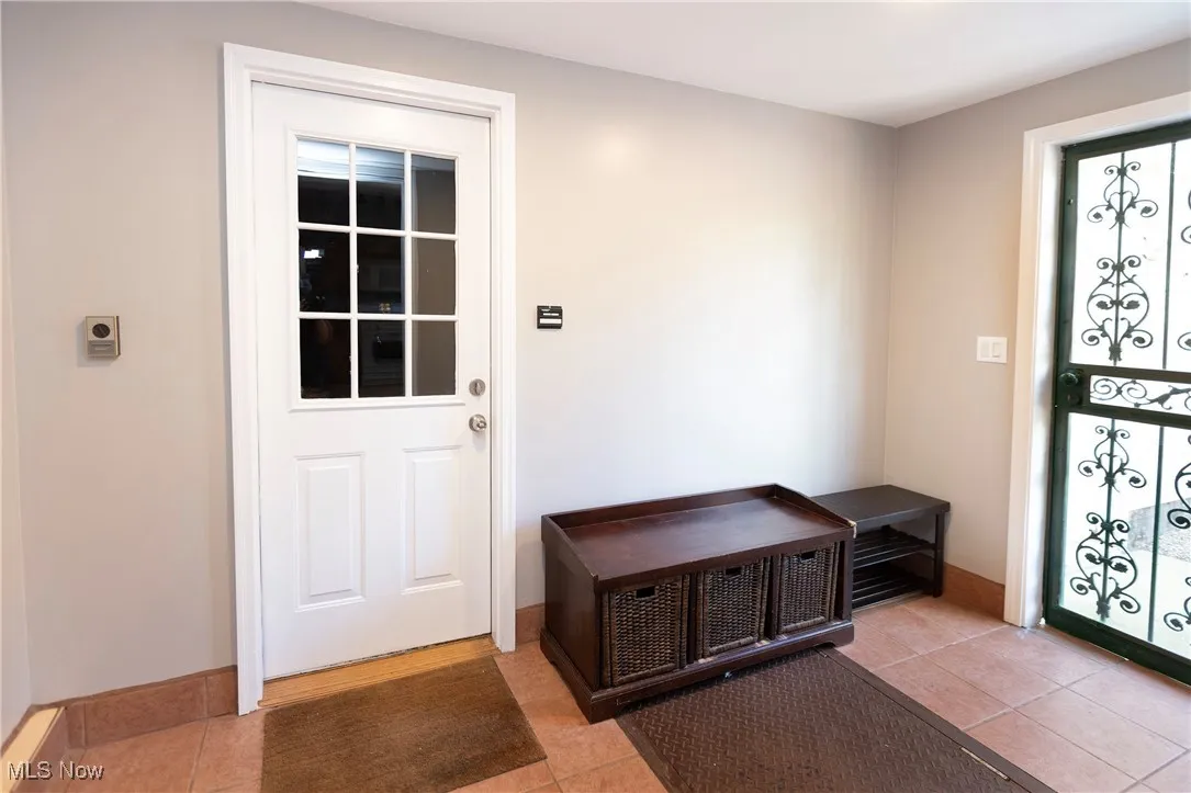 Mudroom featuring ceramic tile with access to back yard and 2 car garage!