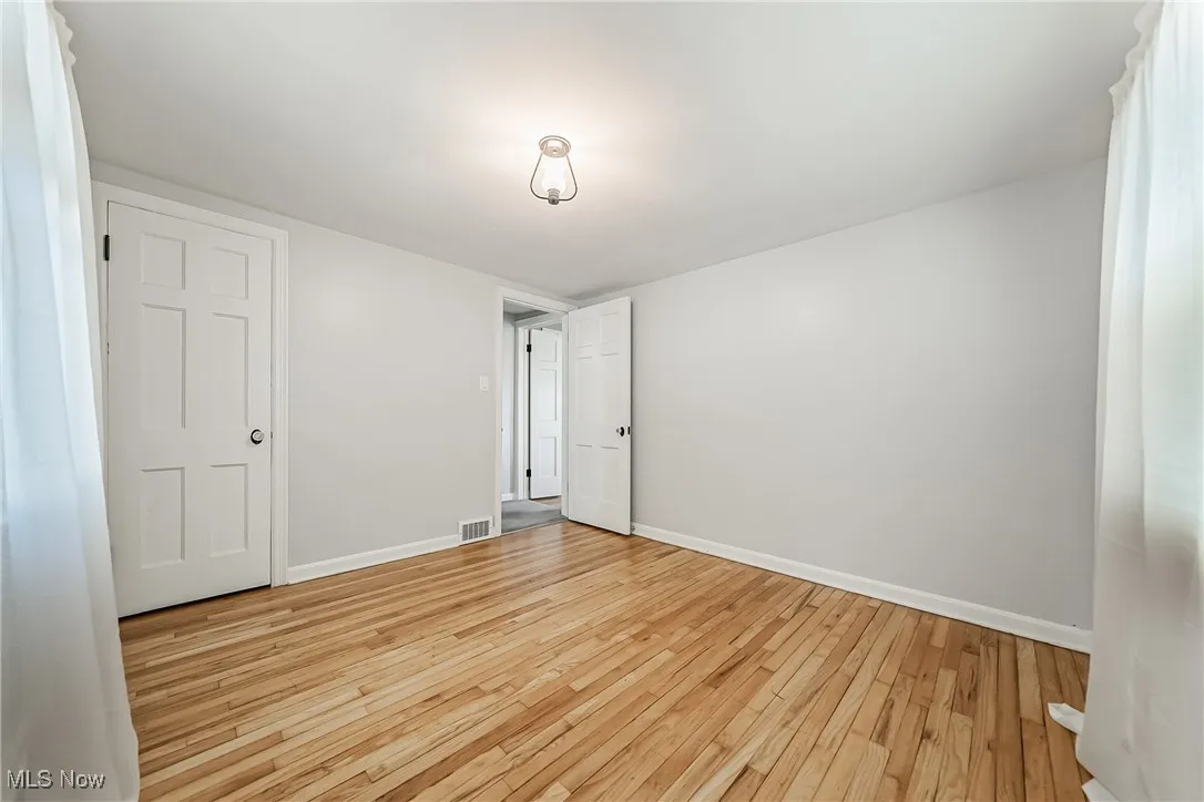 Unfurnished bedroom with light wood-style floors and baseboards