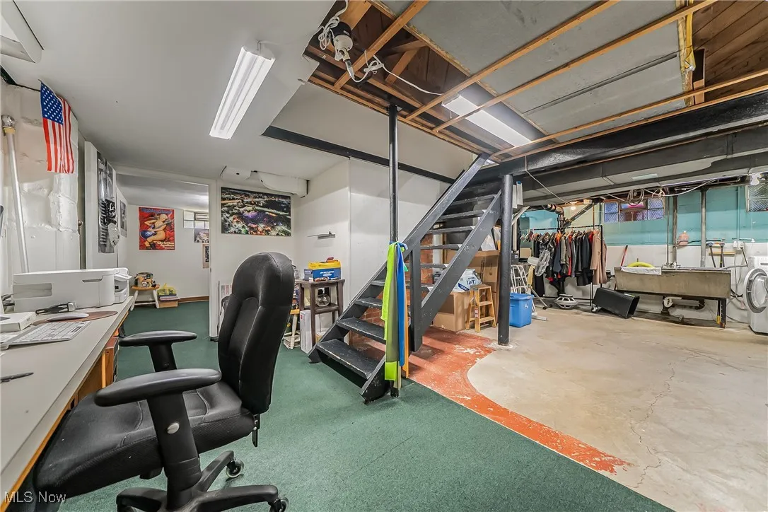 Unfinished below grade area with stairs and washer / dryer