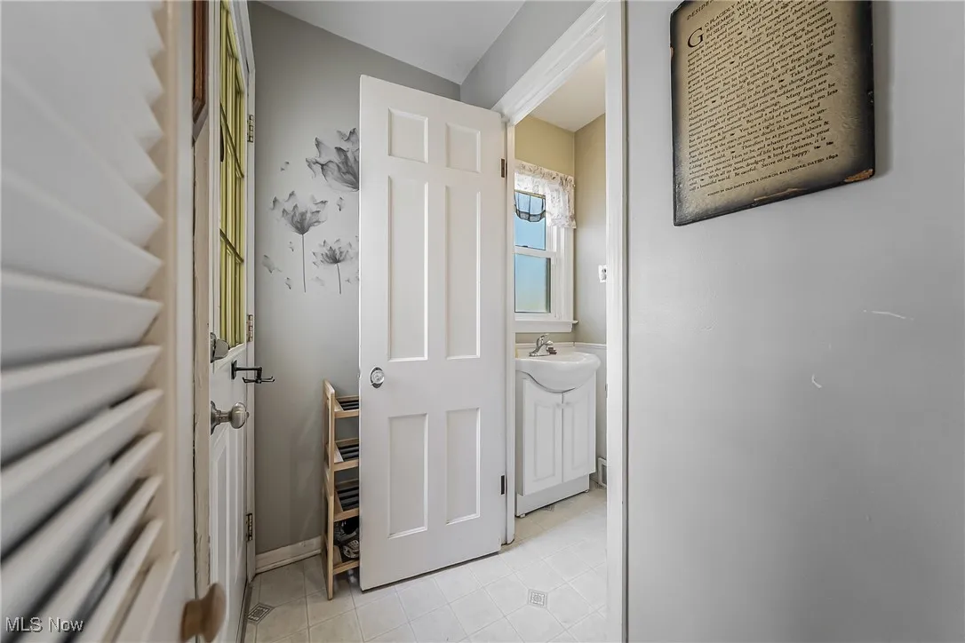Corridor featuring light tile patterned floors and a sink