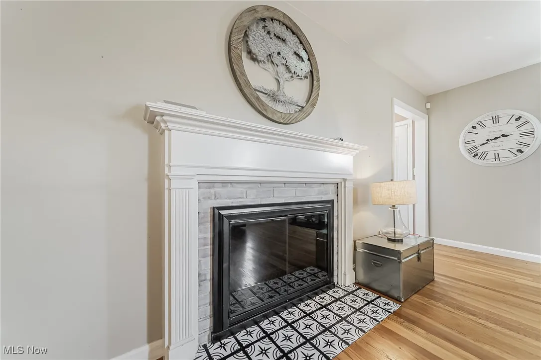 Detailed view of wood finished floors and a brick fireplace