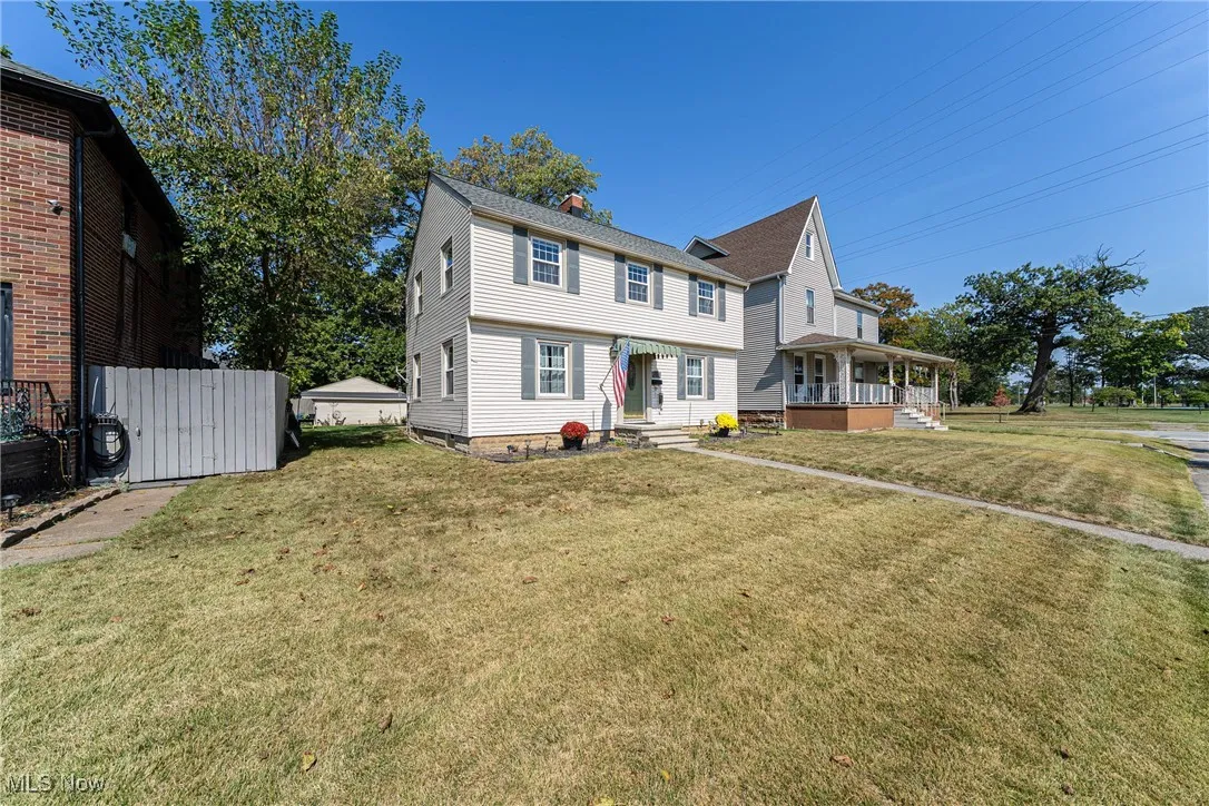 View of front of property with a front lawn, covered porch, and a chimney