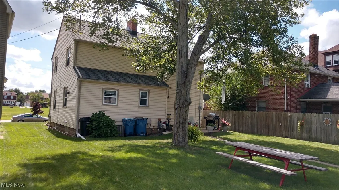 Rear view of property featuring a patio area and a shingled roof