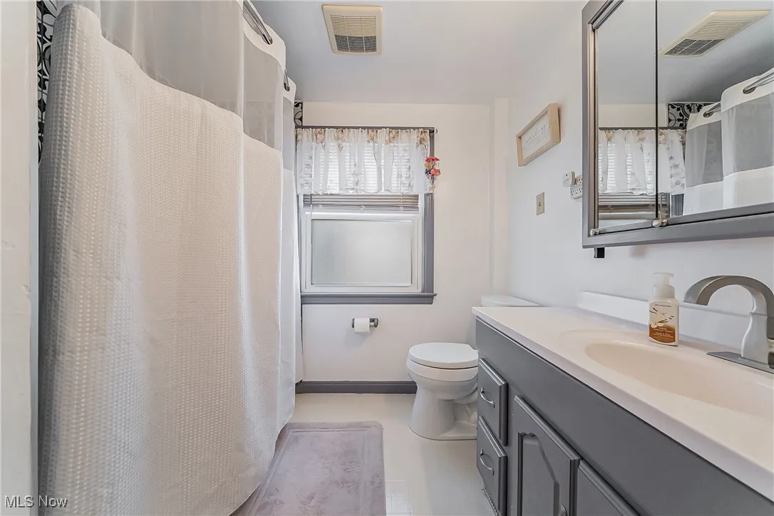 Full bathroom featuring vanity and curtained shower