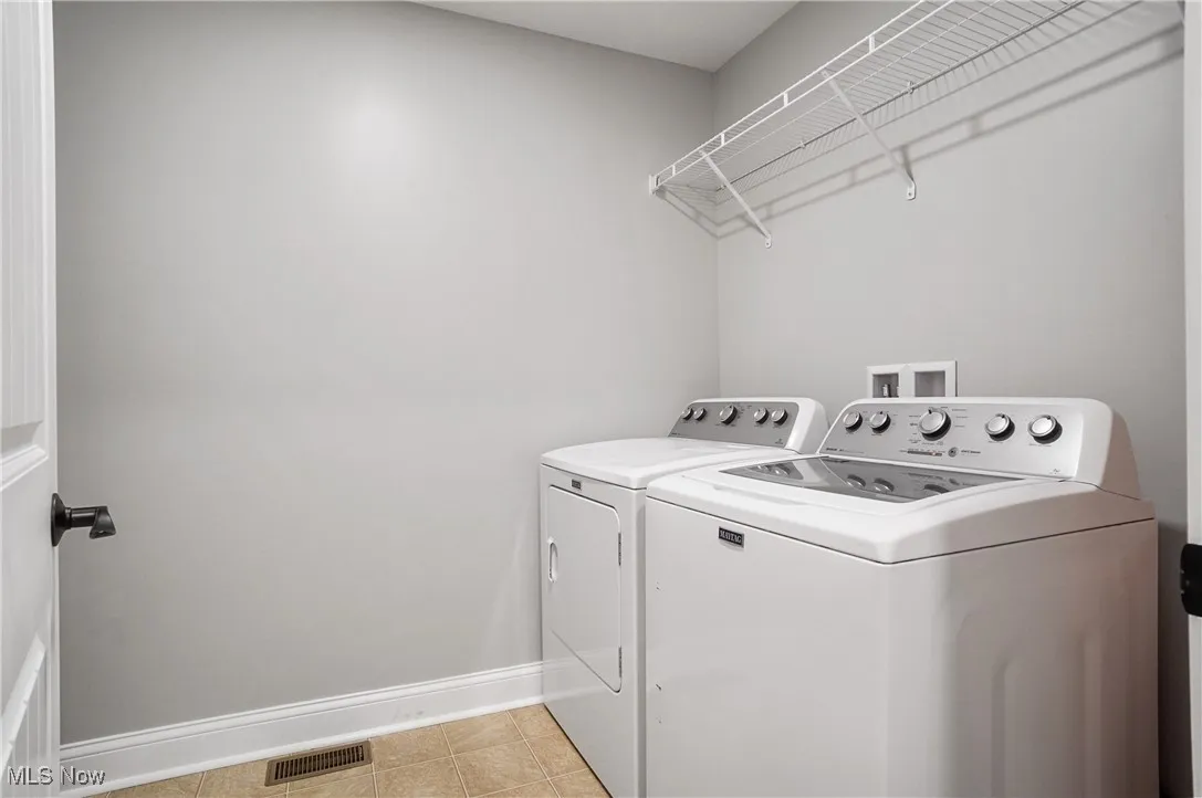Washroom featuring independent washer and dryer and light tile patterned floors
