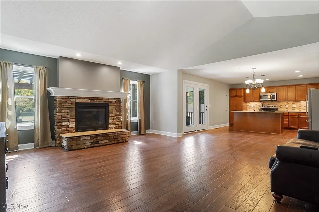 Living area with recessed lighting, a chandelier, healthy amount of natural light, dark wood-style floors, and a fireplace