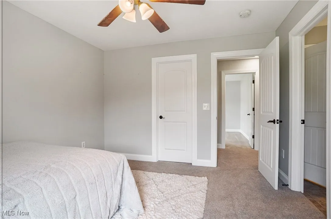 Carpeted bedroom featuring baseboards and a ceiling fan