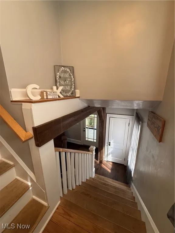 Stairs featuring wood finished floors and baseboards