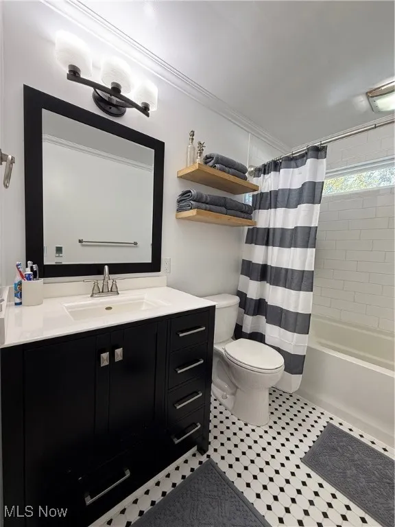 Bathroom featuring shower / bath combination with curtain, vanity, and ornamental molding