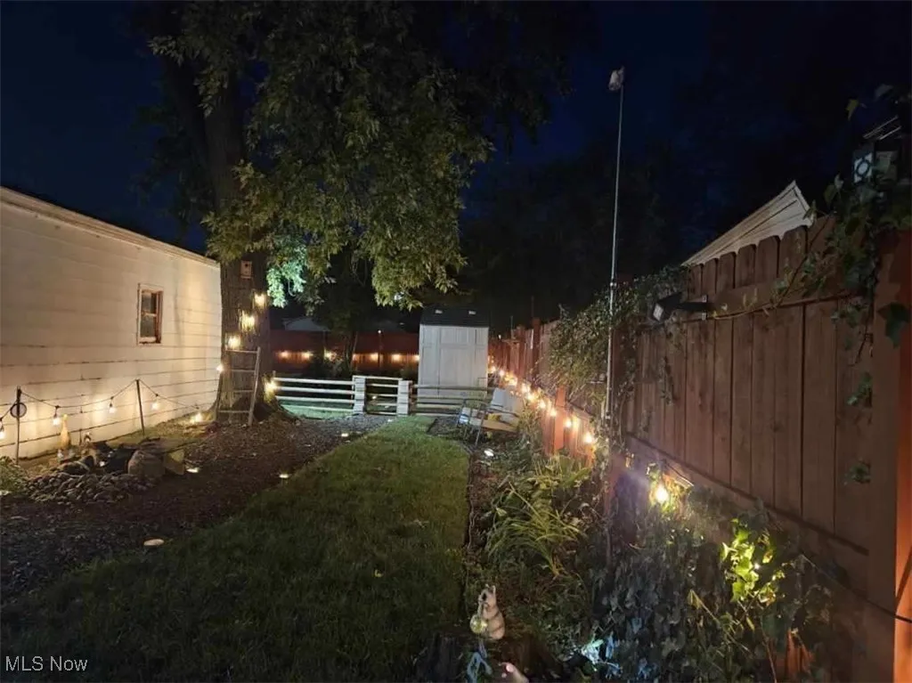 Yard at twilight with a fenced backyard and a shed