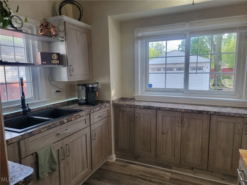 Kitchen with dark wood-style floors and dark stone countertops