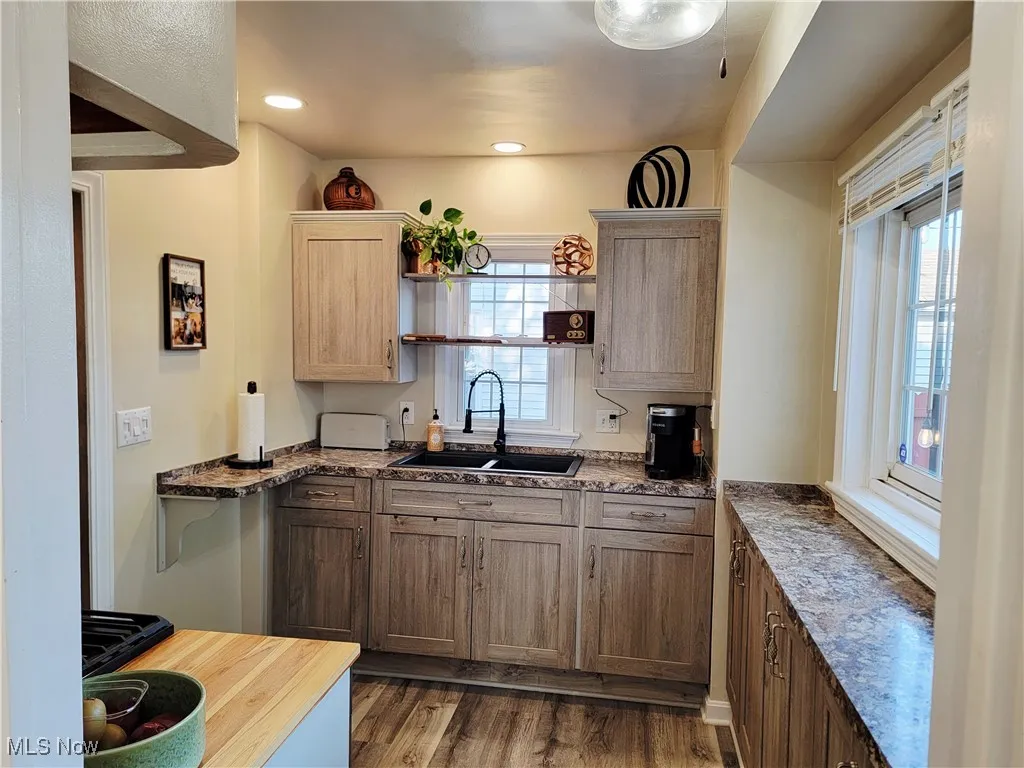 Kitchen featuring light wood-style flooring, recessed lighting, and dark stone counters