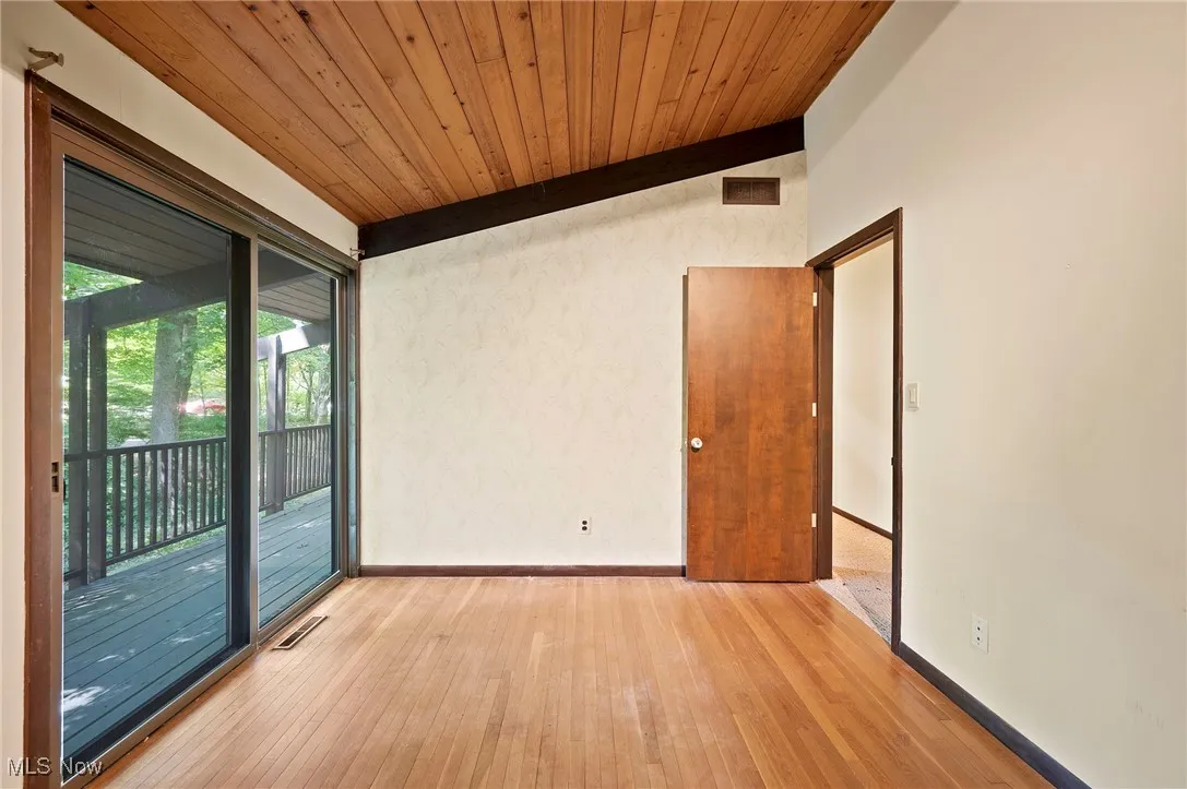 Spare room with light wood-type flooring and wooden ceiling