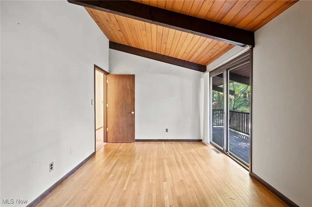 Unfurnished room with light wood-style floors and wood ceiling