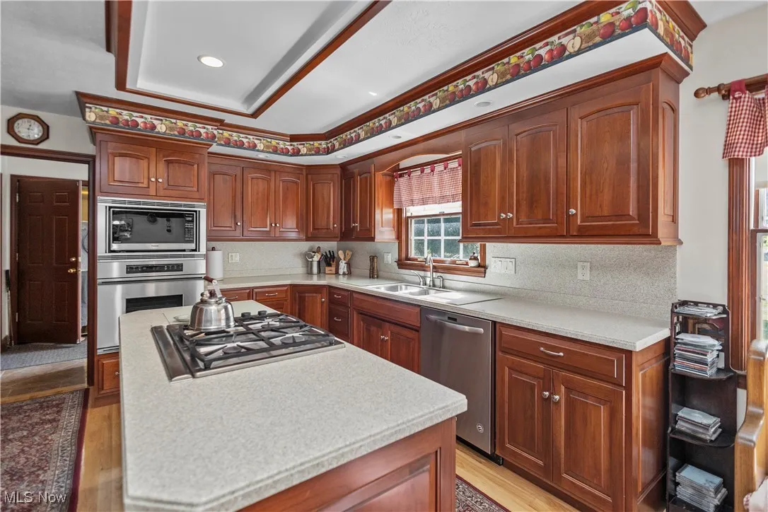 Kitchen featuring stainless steel appliances, a center island, recessed lighting, light wood-style floors, and decorative backsplash