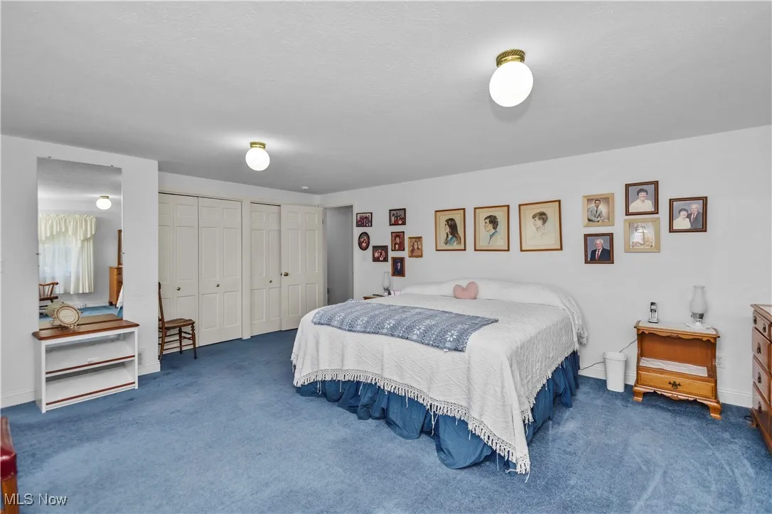 Bedroom with multiple closets and carpet floors