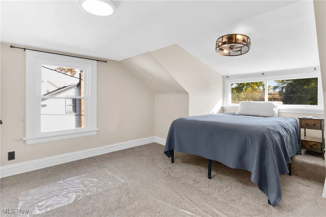 Bedroom with carpet flooring and vaulted ceiling