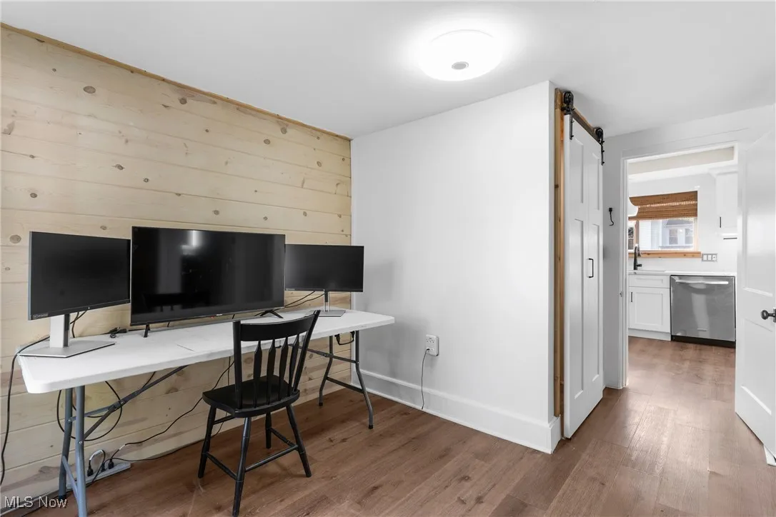 Office featuring light wood-style floors and a barn door