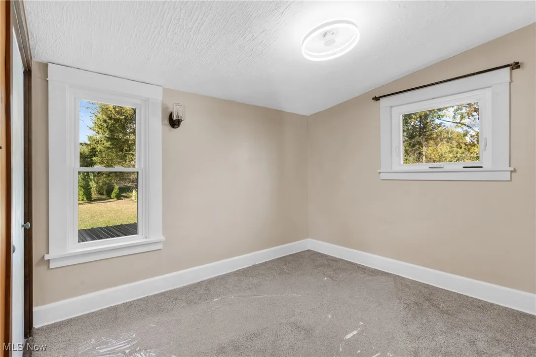 Empty room featuring carpet flooring and a textured ceiling