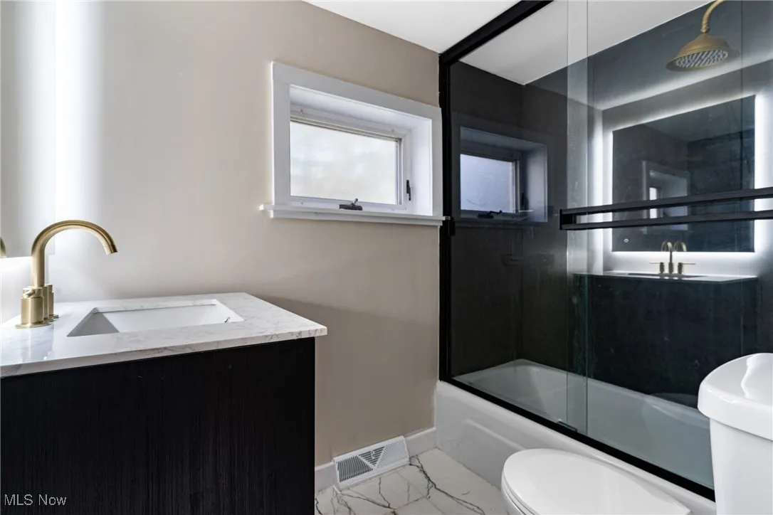 Full bathroom with vanity and combined bath / shower with glass door