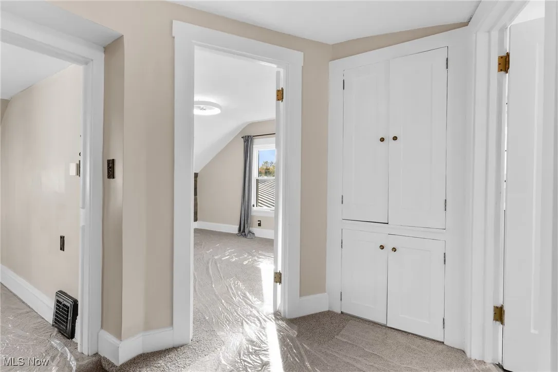 Hallway with baseboards and vaulted ceiling