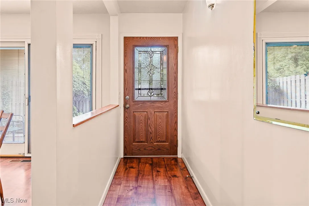 Doorway to outside featuring wood finished floors and baseboards