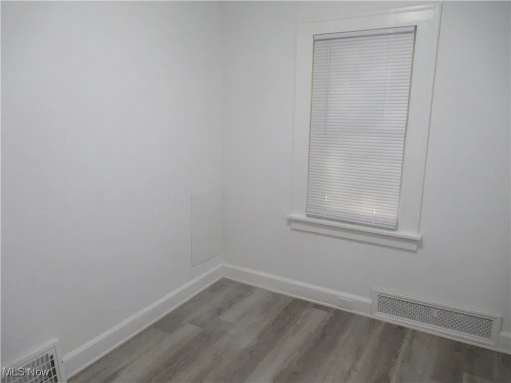 Empty room with baseboards and light wood-style flooring