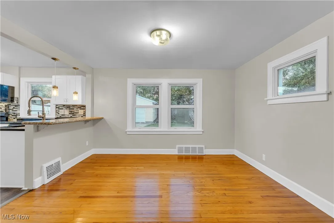 Unfurnished living room featuring light wood finished floors and baseboards