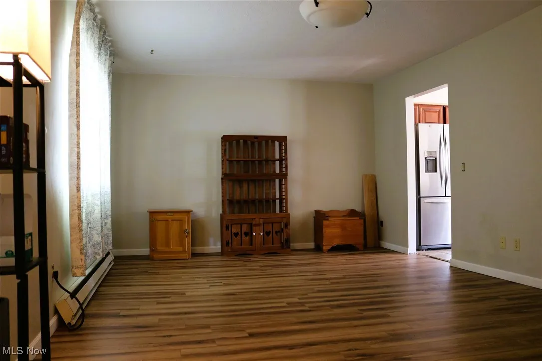 Spare room with wood finished floors and a baseboard radiator