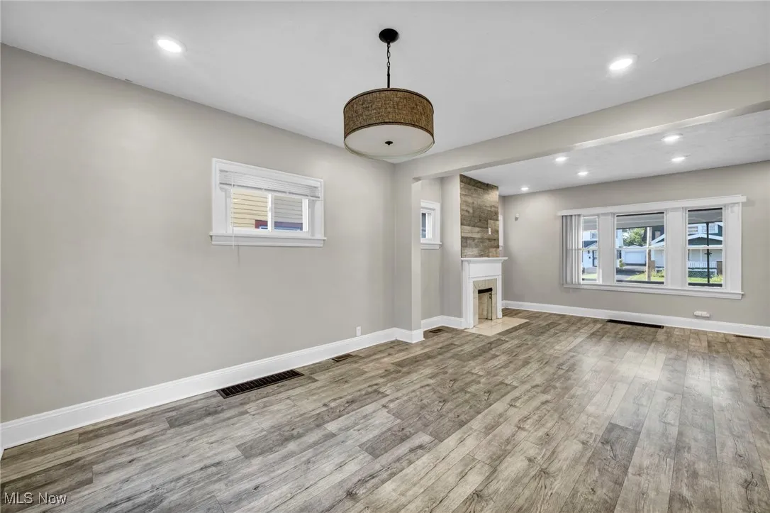 Unfurnished living room featuring light wood-type flooring, recessed lighting, and a large fireplace