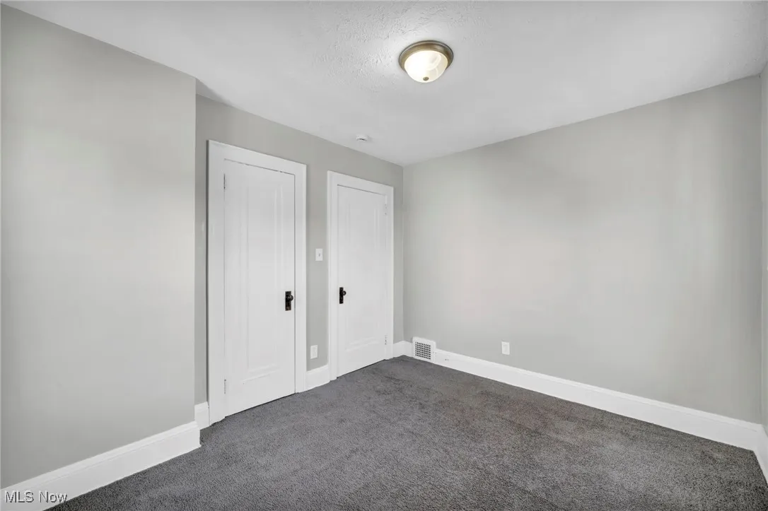 Unfurnished bedroom featuring carpet floors, a textured ceiling, and a closet