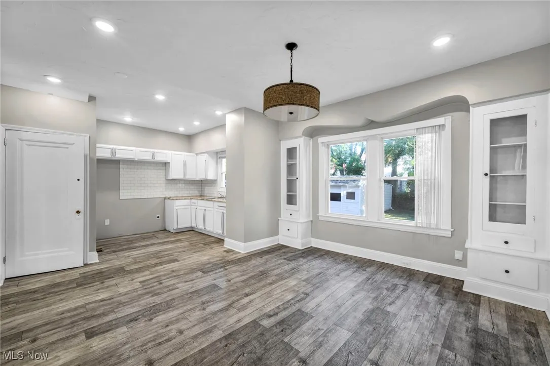 Unfurnished living room featuring dark wood finished floors, recessed lighting, and built in shelves